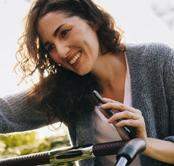 Woman leaning over a stroller and smiling