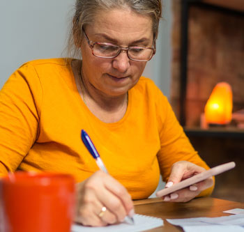 Woman in orange shirt taking notes