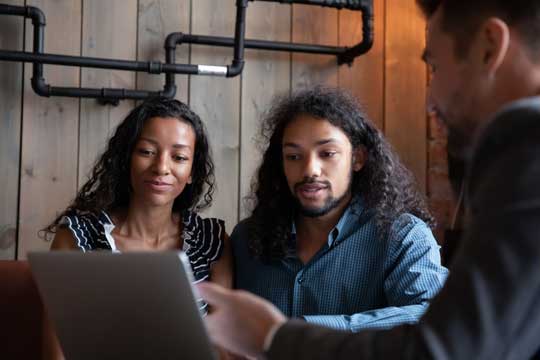 A couple sitting at a table with an investment advisor