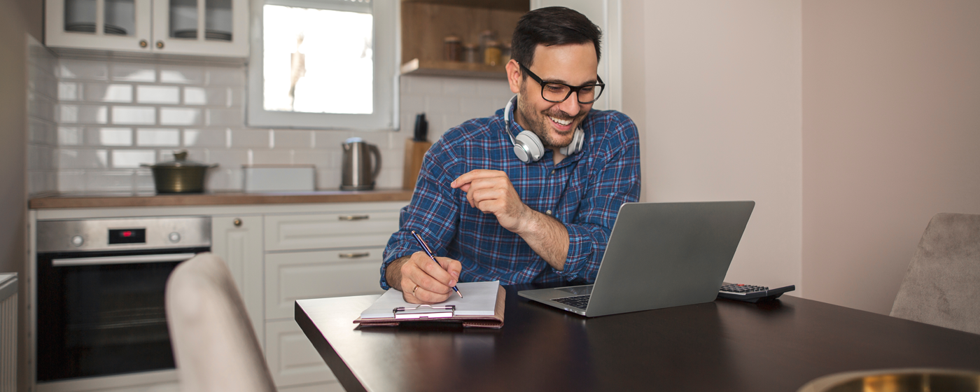 Man smiling and working at his laptop