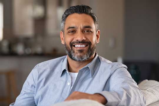 Man with graying hair, smiling straight ahead